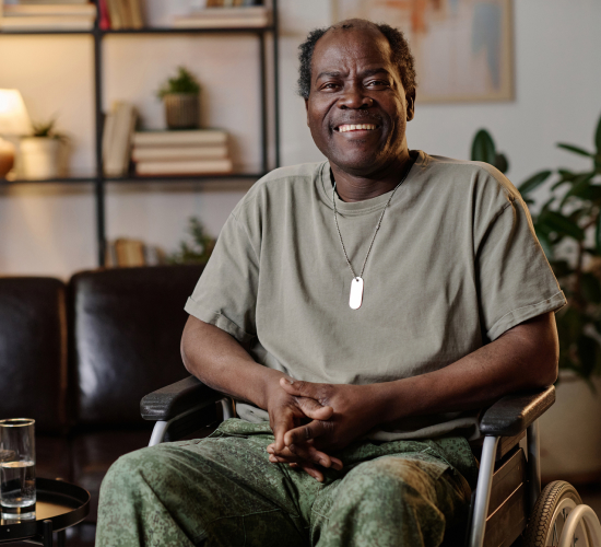 Man sitting in a wheelchair smiling.