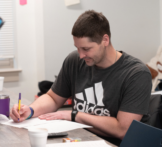 Man sitting at a table filling out paperwork